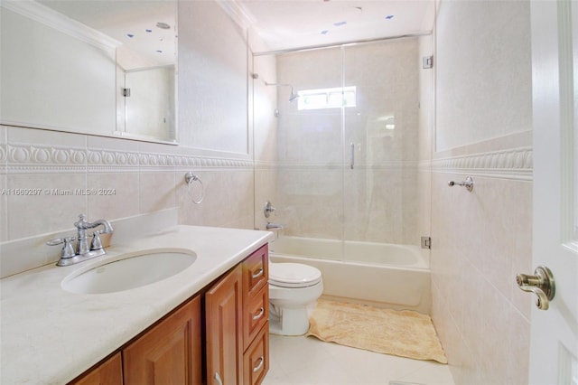 full bathroom with tile walls, vanity, toilet, and ornamental molding