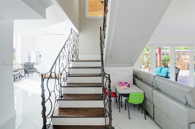 staircase featuring french doors and ornamental molding