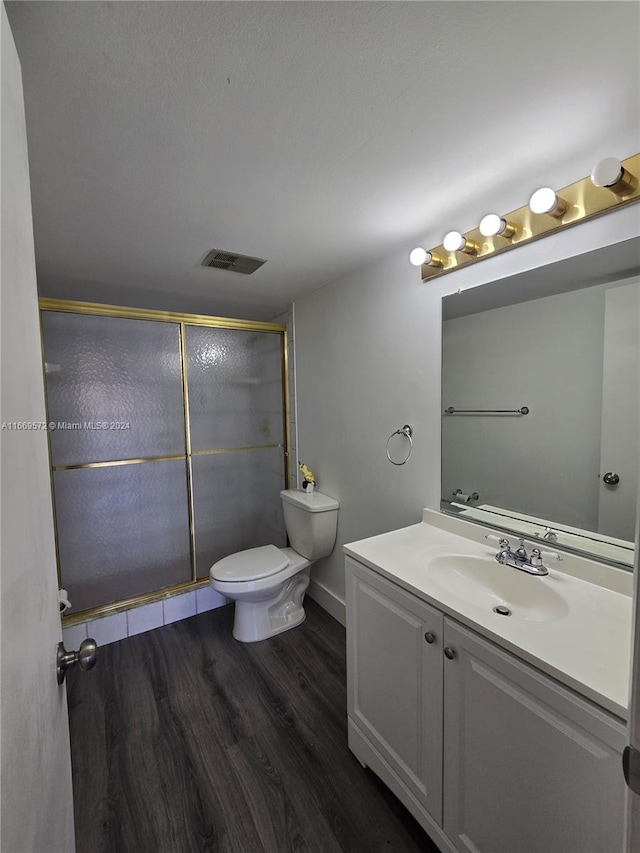 bathroom featuring an enclosed shower, hardwood / wood-style flooring, vanity, and toilet