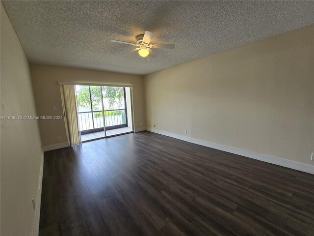 empty room featuring ceiling fan, dark wood-type flooring, and a textured ceiling