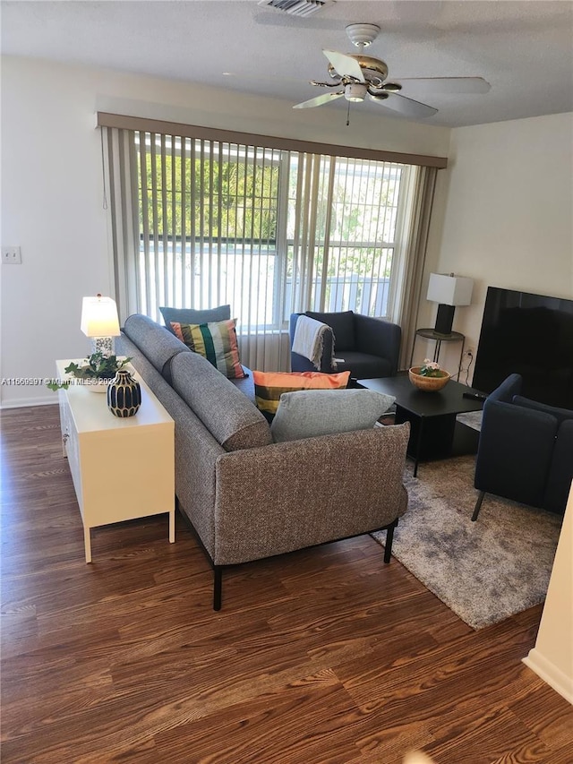 living room featuring ceiling fan, dark hardwood / wood-style floors, and a wealth of natural light