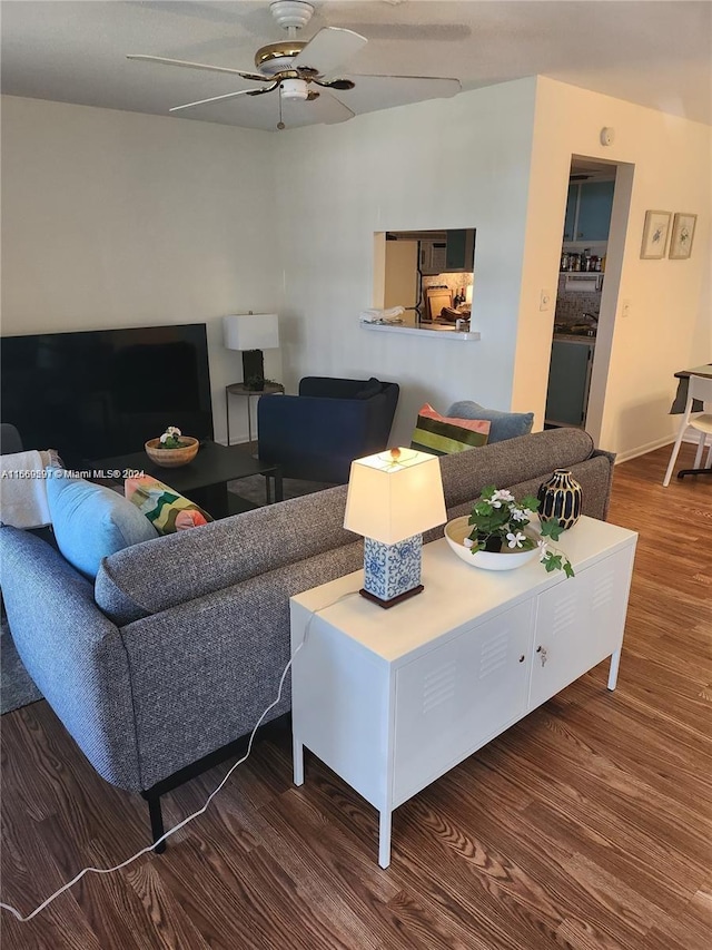 living room with ceiling fan and dark wood-type flooring