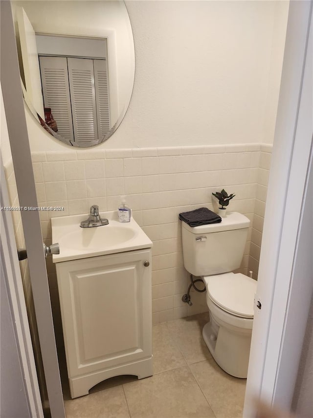 bathroom with vanity, tile walls, toilet, and tile patterned floors