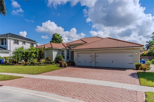 mediterranean / spanish home with a front yard and a garage