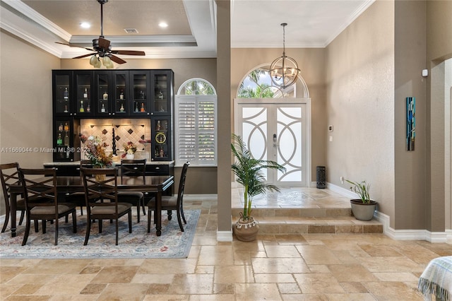 foyer with ceiling fan with notable chandelier and crown molding