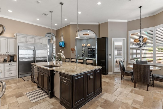 kitchen featuring white cabinets, appliances with stainless steel finishes, pendant lighting, and ornamental molding