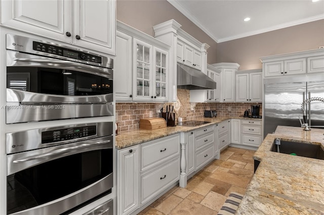 kitchen with light stone counters, white cabinets, backsplash, stainless steel appliances, and sink