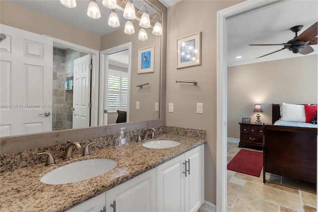 bathroom featuring ceiling fan with notable chandelier, vanity, and tiled shower