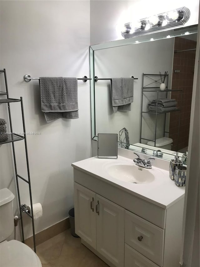 bathroom with vanity, toilet, and tile patterned floors