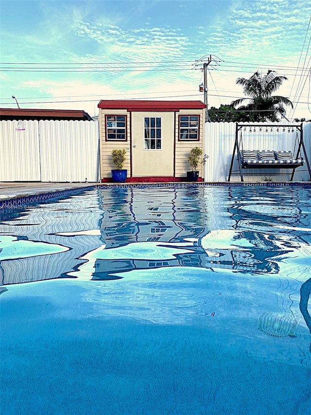 view of pool with an outbuilding