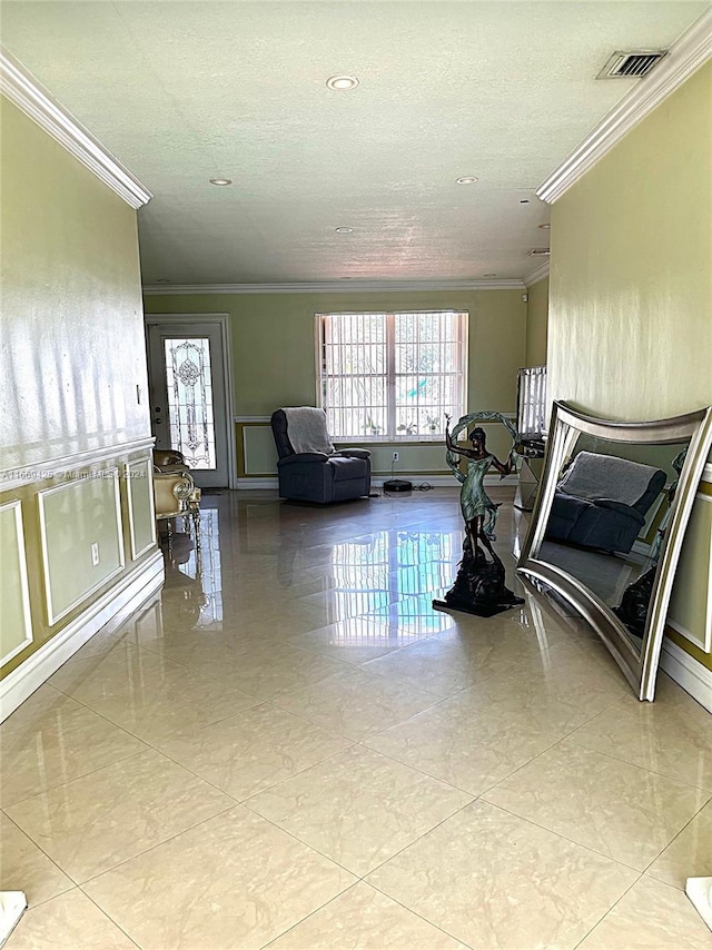 living room with a textured ceiling, crown molding, and light tile patterned floors