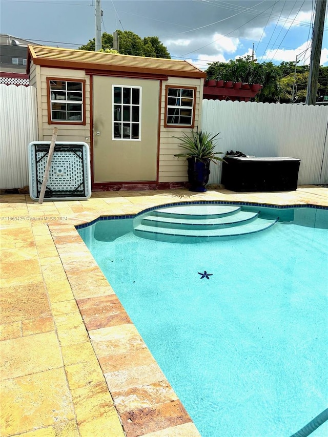 view of pool featuring a patio area and an outbuilding