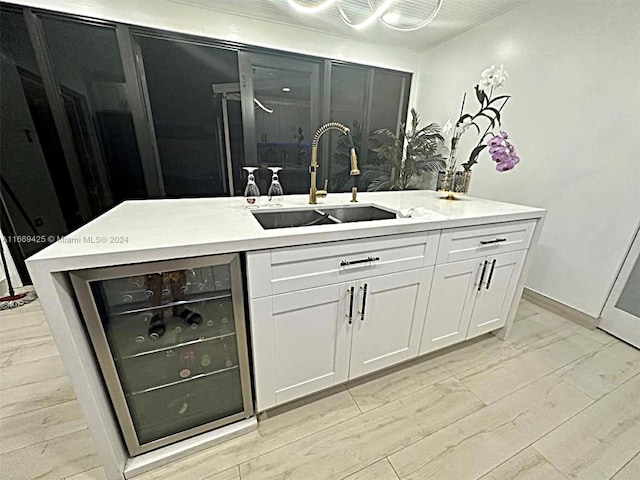 bar featuring light hardwood / wood-style floors, sink, wine cooler, and white cabinets