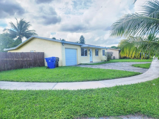 view of front of property with a front yard and a garage