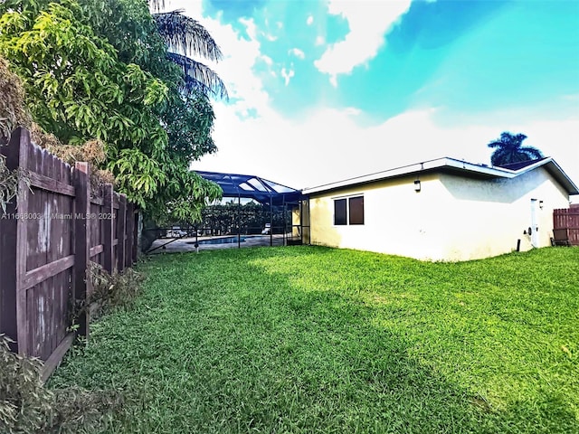 view of yard with a fenced in pool and a lanai