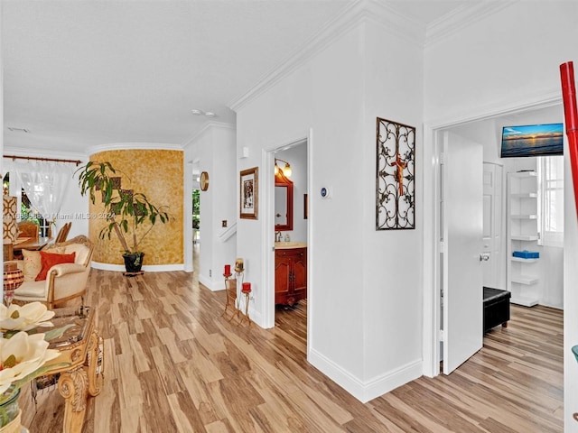 corridor with ornamental molding and light hardwood / wood-style flooring