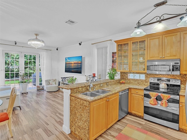 kitchen featuring kitchen peninsula, stainless steel appliances, sink, light stone counters, and light hardwood / wood-style floors