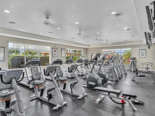 gym featuring a textured ceiling and ceiling fan