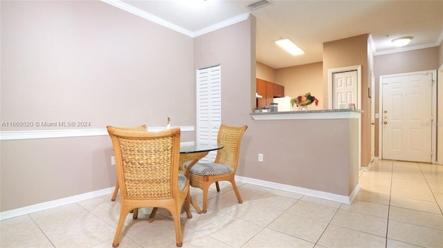 dining area with crown molding and light tile patterned floors