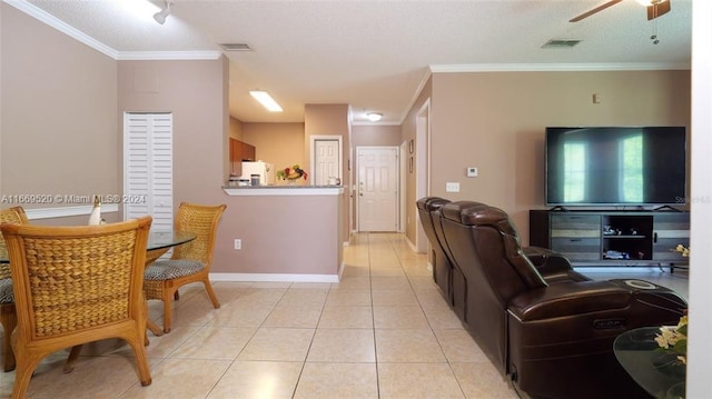 living room featuring ceiling fan, light tile patterned floors, and ornamental molding