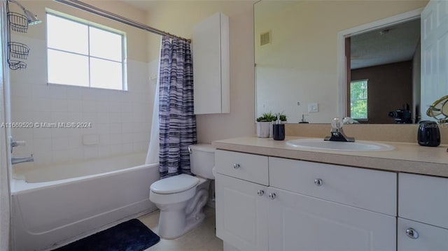 full bathroom featuring vanity, toilet, shower / bathtub combination with curtain, and a healthy amount of sunlight