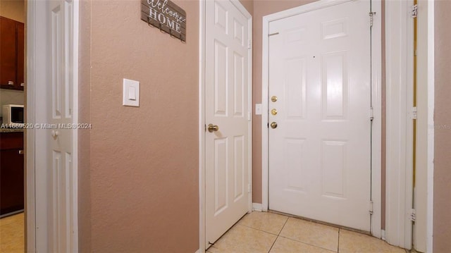 doorway with light tile patterned flooring