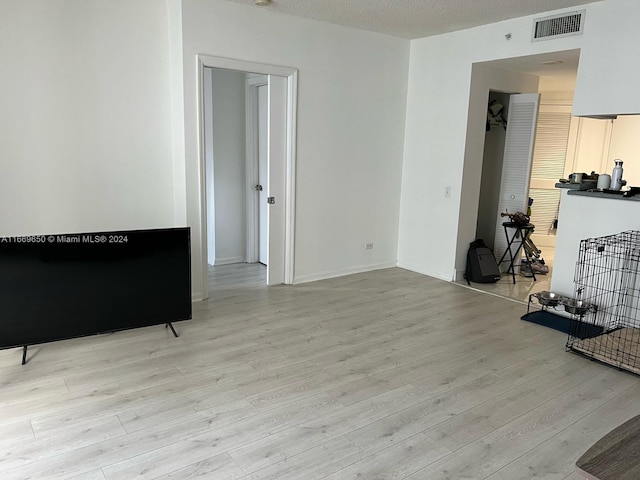 living room featuring a textured ceiling and light hardwood / wood-style floors