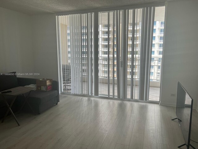 701 Brickell Key Blvd Unit 1108, Miami, FL 33131 - interior space with a wall of windows, wood finished floors, baseboards, and a textured ceiling
