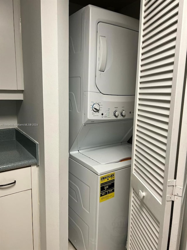 washroom with stacked washing maching and dryer