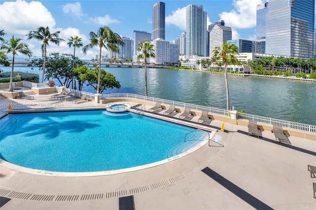 view of swimming pool with a water view and a patio area