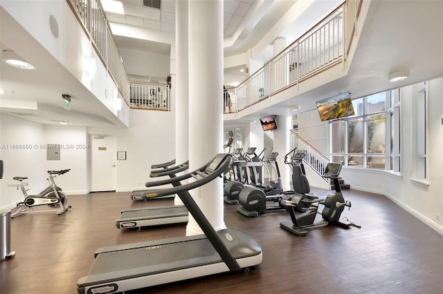 workout area with a high ceiling and dark wood-type flooring