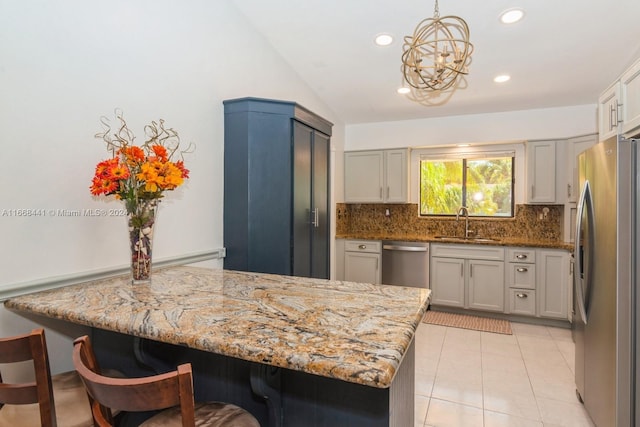 kitchen with kitchen peninsula, vaulted ceiling, pendant lighting, and stainless steel appliances