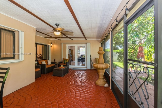 unfurnished sunroom featuring ceiling fan and a healthy amount of sunlight