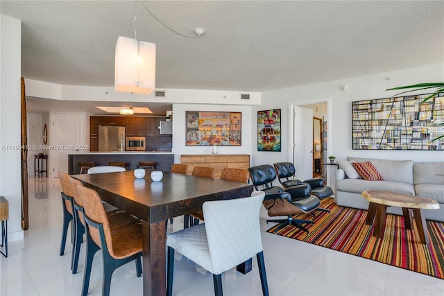 tiled dining area featuring a textured ceiling