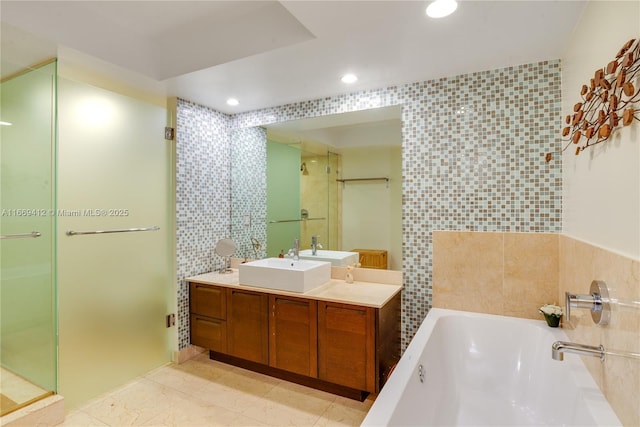 bathroom featuring tile walls, vanity, and shower with separate bathtub