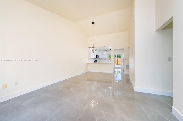 unfurnished living room featuring high vaulted ceiling