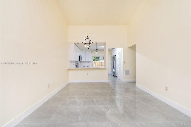 unfurnished living room with a high ceiling