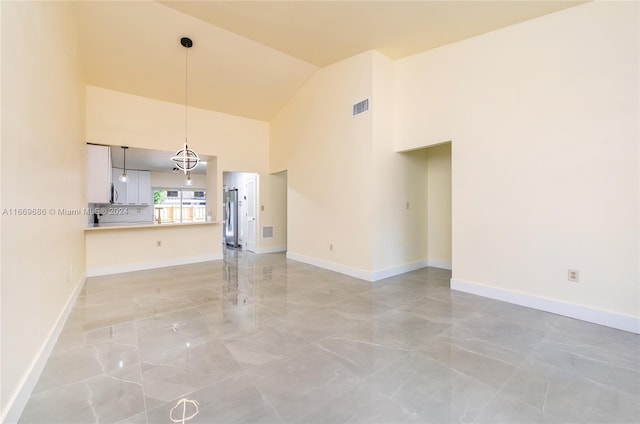 unfurnished living room with high vaulted ceiling