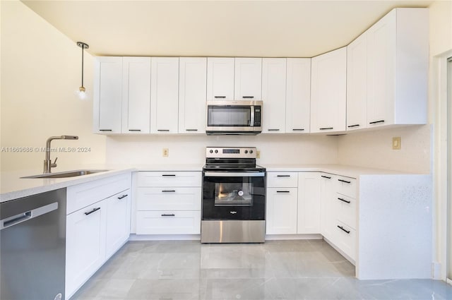 kitchen with pendant lighting, stainless steel appliances, white cabinetry, and sink