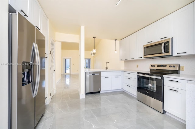 kitchen featuring sink, kitchen peninsula, decorative light fixtures, white cabinetry, and appliances with stainless steel finishes