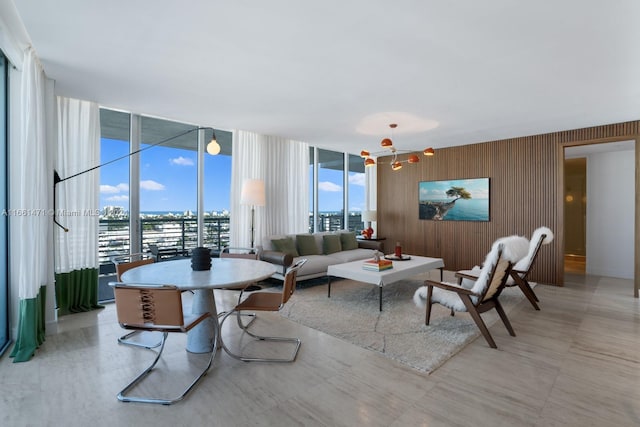 living room featuring floor to ceiling windows, a wealth of natural light, and wood walls