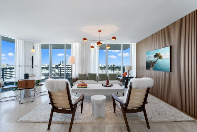 living room featuring floor to ceiling windows, a healthy amount of sunlight, and wooden walls