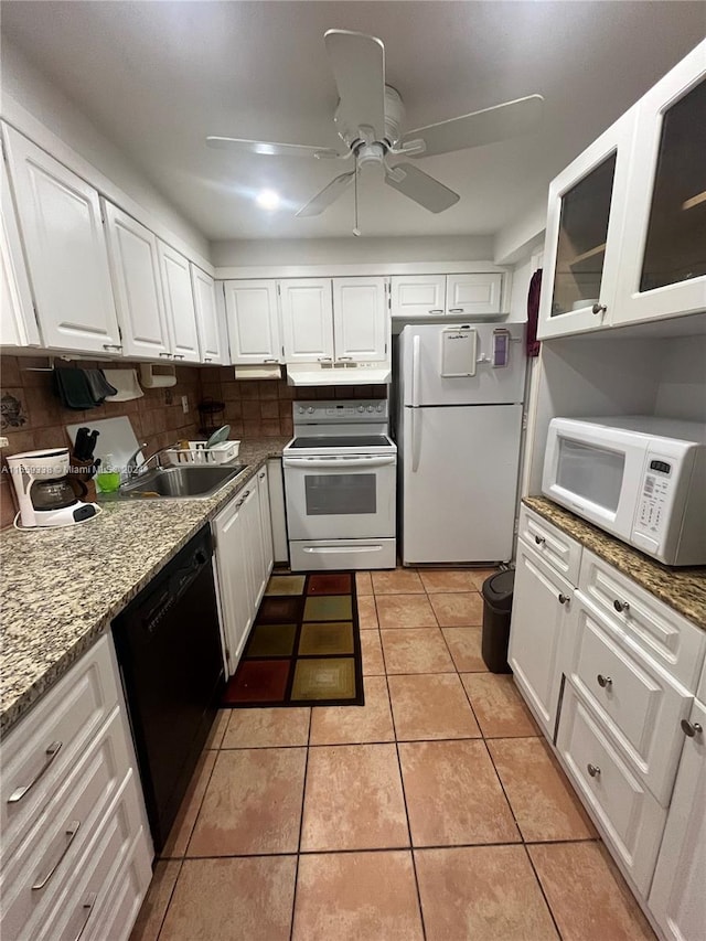 kitchen featuring light stone counters, white cabinetry, light tile patterned flooring, sink, and white appliances