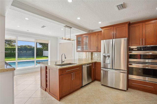 kitchen with decorative backsplash, light stone counters, stainless steel appliances, a textured ceiling, and sink