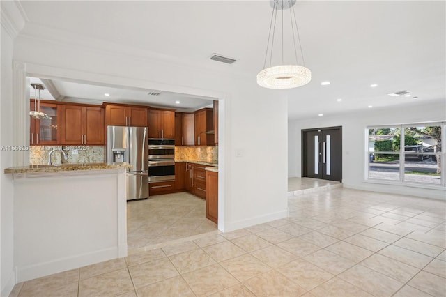 kitchen with light tile patterned flooring, light stone counters, backsplash, kitchen peninsula, and stainless steel appliances