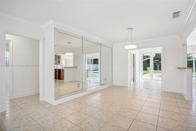 tiled empty room featuring french doors and crown molding