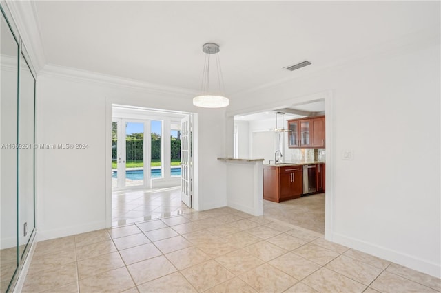 spare room featuring light tile patterned flooring, crown molding, and sink