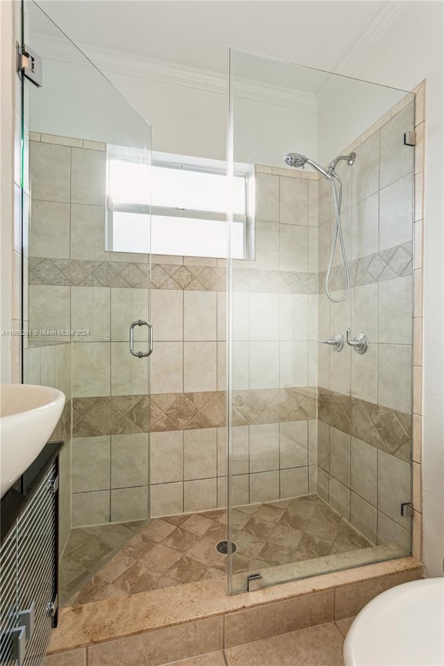 bathroom featuring ornamental molding, vanity, and an enclosed shower