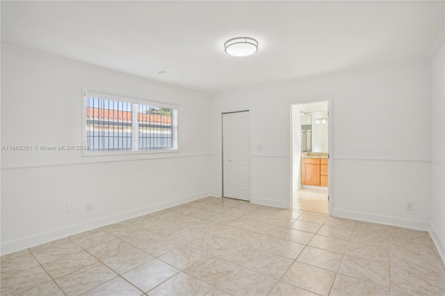 unfurnished room with ornamental molding and light tile patterned floors