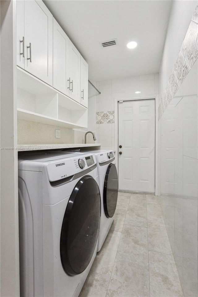 laundry area featuring cabinets, independent washer and dryer, and light tile patterned flooring